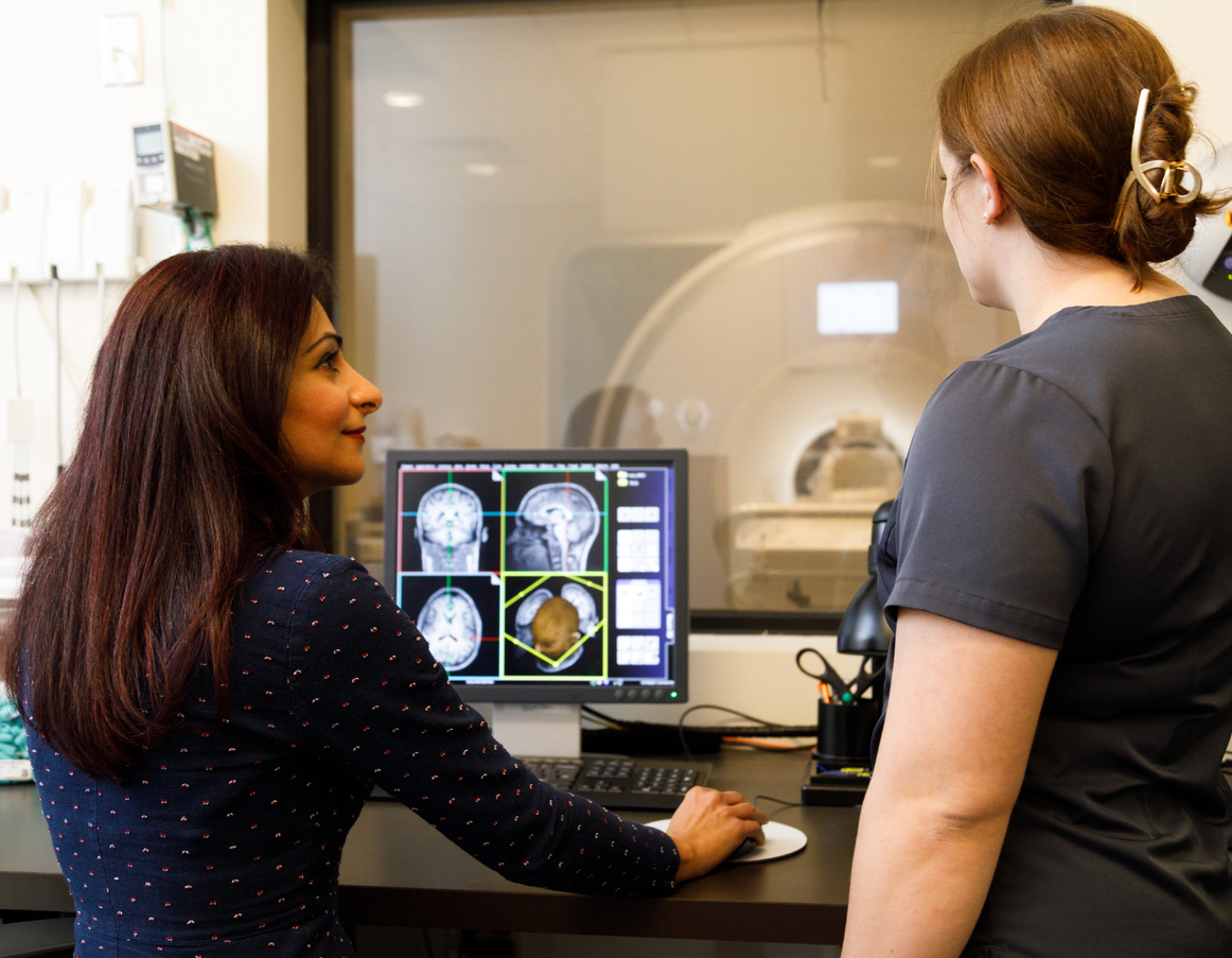 A doctor and a tech go over the results of an fMRI scan before TMS treatment