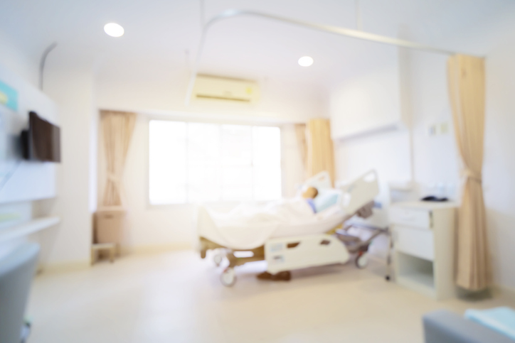 Patient on hospital bed, medical blur interior background white room ward with nursing care or healthcare recovery treatment