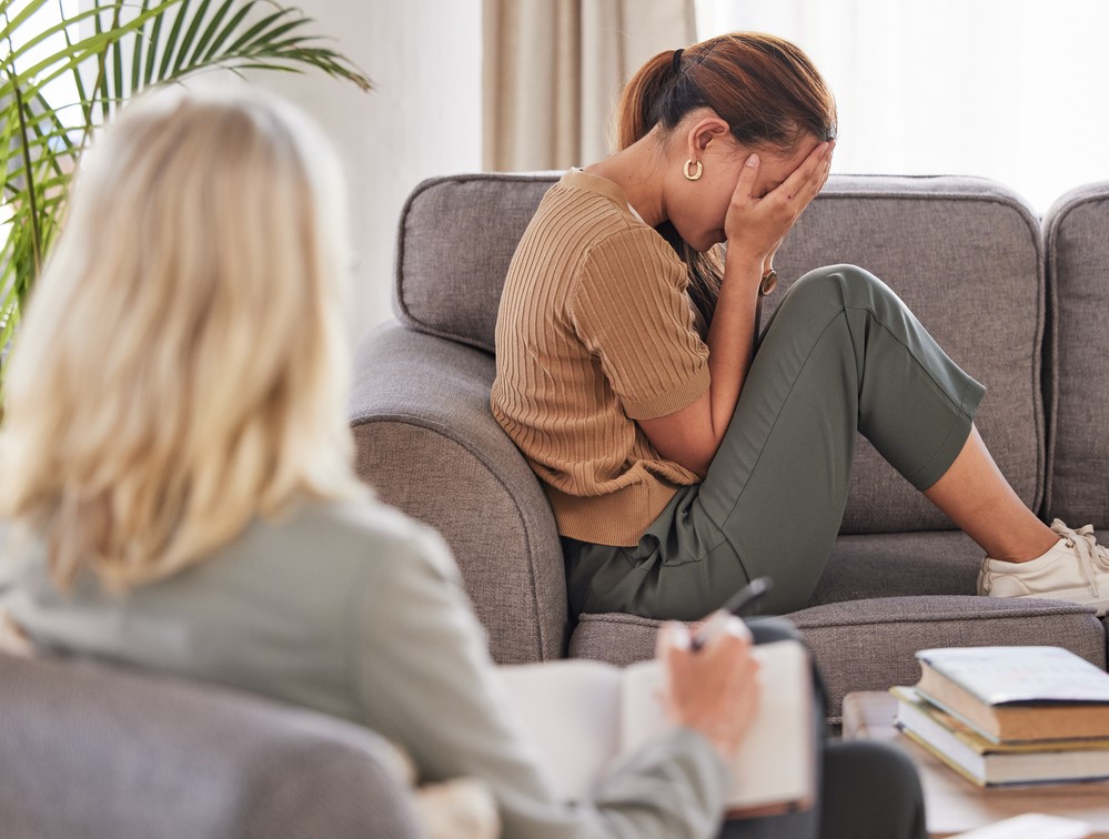 Women with depression crying on a couch in front of her psychiatrist